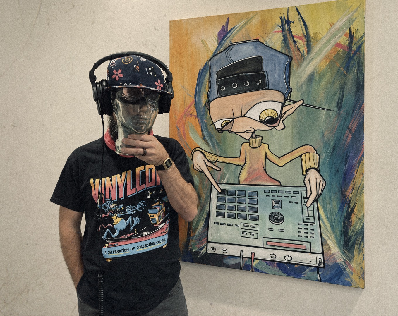 Taylor Jordan wearing headphones beside original artwork